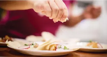  ?? PHOTOS DARRYL DYCK/THE CANADIAN PRESS ?? Jayne Zhou squeezes lime juice on cajun fish tacos prepared from a Hello Fresh meal kit, at her home in Vancouver, B.C., on Wednesday December 6, 2017. Home-delivered meal kits have quickly grown into a $120-million industry in Canada, according to...