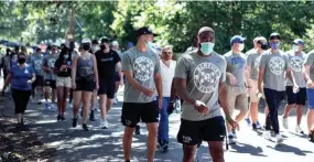  ?? ARIEL COBBERT/THE COMMERCIAL APPEAL ?? Hundreds of athletes, coaches and staff participat­e in the University of Memphis Unity Walk from South Campus in Memphis on June 14 in reaction to the death of George Floyd. The school is ending diversity training in response to an executive order issued by President Donald Trump.