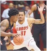  ?? ADOLPHE PIERRE-LOUIS/
JOURNAL ?? Lobo guard Troy Simons, right, defends UNLV’s Jovan Mooring in Dreamstyle Arena on Feb. 25. Simons, who was at UNM one season, is expected to transfer to be closer to his Pittsburgh home.