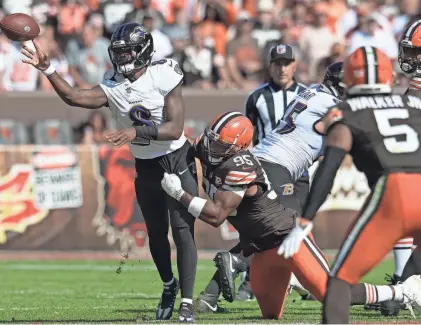  ?? KEN BLAZE/USA TODAY SPORTS ?? Ravens quarterbac­k Lamar Jackson throws a pass as Browns defensive end Myles Garrett rushes on Oct. 1 in Cleveland.