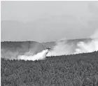  ?? THOMAS PEIPERT/AP ?? A plane drops water Wednesday near Las Vegas, New Mexico. The fire has torched more than 250 square miles.