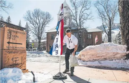  ?? Kelsey Brunner, The Aspen Times ?? A Pitkin County election specialist adjusts a “Vote Here” flag outside the county government building to encourage voters to cast their ballots on Super Tuesday in Aspen.