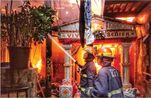  ?? ALDO NELBERT BANAYNAL ?? Firefighte­rs battle the conflagrat­ion that hit hundreds of structures, including this chapel of Senior Sto. Niño in Barangay Pasil.