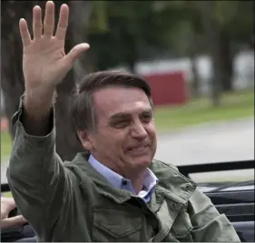  ??  ?? In this Oct. 28 photo, presidenti­al frontrunne­r Jair Bolsonaro waves after voting in the runoff election in Rio de Janeiro, Brazil. AP PHOTO/SILVIA IZQUIERDO