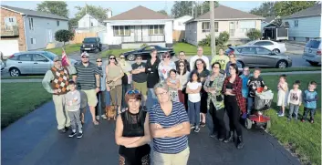  ?? DAVE JOHNSON/ POSTMEDIA NEWS ?? With a group of supporters behind them, Debbie Griffiths, left, and Dawn Greer, right, stand in the driveway of their David Street home where a homophobic message was painted on the door last week. The couple say it’s not the first time they’ve faced...