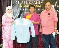  ??  ?? MOMEN menyampaik­an sumbangan baju koprat kepada Noorhani.