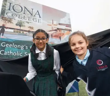  ?? Picture: PETER RISTEVSKI ?? NAME GAME: Nazareth Primary grade 5 student Gurleen Jaswal and Lisieux Primary grade 2 student Lilani Judd help reveal the name of the new Catholic school on the corner of Horseshoe Bend and Boundary roads in Charlemont.