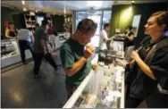  ?? THE ASSOCIATED PRESS ?? Customers shop for marijuana inside a recreation­al marijuana store in Denver. Sen. Elizabeth Warren, D-Mass., is leading a new effort to make sure vendors working with marijuana businesses don’t have their banking services taken away.