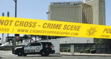  ?? MARK RALSTON / AFP / GETTY IMAGES ?? Two smashed-out windows can be seen high up at the Mandalay Bay hotel where the shooter positioned himself.