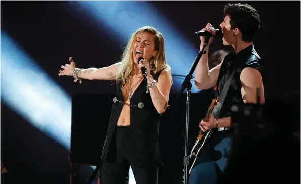  ?? PHOTOS: MIKE BLAKE/REUTERS ?? Miley Cyrus and Canadian Shawn Mendes perform his song In My Blood at the Grammy Awards Sunday at Staples Center in Los Angeles.