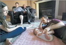  ?? Isaac Hale For The Times ?? BRIAN AND RACHAEL Stoll of Utah play with daughter Everly as Rachael’s mother and stepfather, Michelle Bacca-Llamas and Hector Llamas, look on.