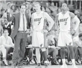  ?? LYNNE SLADKY/AP ?? Miami Heat head coach Erik Spoelstra, left, talks with Goran Dragic and Dwyane Wade during the second half of an NBA basketball game against the Brooklyn Nets on Monday.