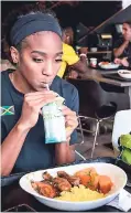  ??  ?? Four-hundred-metre hurdler Leah Nugent takes a sip of her Grace Coconut Water before enjoying Grace Jerk Barbecue Chicken, seasoned rice and herb-roasted potatoes.