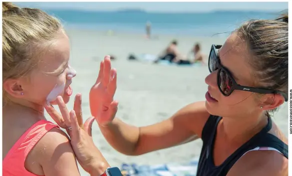  ?? amaNDa saBga / BostoN heralD ?? SUNNY DAY: Emmie Fagone, 3, reacts to her mom, Sarah, applying sunblock to her face at Revere Beach on Monday.
