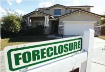  ?? AP FILE PHOTO/ROSS D. FRANKLIN ?? A foreclosur­e sign sits outside a home for sale in Phoenix.