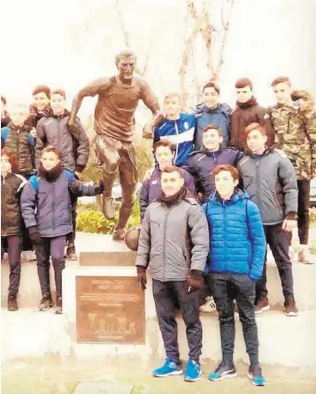 ?? ABC. ?? Jugadores y técnicos del C. D. Antonio Puerta posan con el monumento al jugador en la ciudad deportiva sevillista