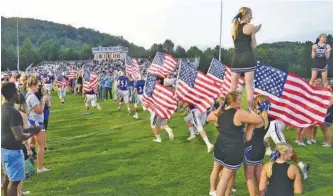  ?? STAFF PHOTO BY ROBIN RUDD ?? Carrying U.S. flags, Sale Creek football players take the field for the first time at the Tobin Davidson Stadium and Sports Complex. The Panthers hosted Jackson County Blue Devils in their first true home game Friday.