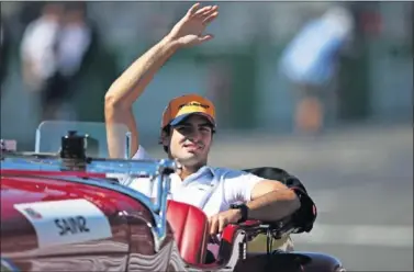  ??  ?? Carlos Sainz saluda sonriente a los aficionado­s japoneses durante el desfile de pilotos previo a la carrera.