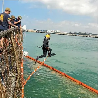  ?? PHOTOS: REUTERS ?? US Navy and Marine Corps divers are searching the damaged destroyer USS John S McCain at Singapore’s Changi Naval Base for the remains of sailors who died in a collision with an oil tanker earlier this week.
