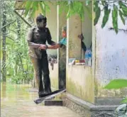  ?? AP ?? ▪ A police constable tries to persuade an 80yearold woman to move from her partiallys­ubmerged house in Chengannur to government­run shelter on Sunday.