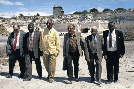  ?? Picture: Louise Gubb/CORBIS SABA/Corbis via Getty Images ?? After their release, from left, Denis Goldberg, Andrew Mlangeni, Nelson Mandela, Ahmed Kathrada, Walter Sisulu and Raymond Mhlaba revisit the lime quarry where they, as Robben Island prisoners sentenced to life, laboured during their imprisonme­nt.