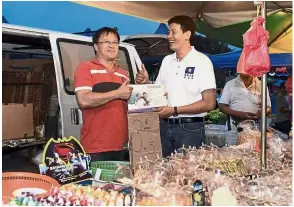  ?? — Bernama ?? May the best man win: Tan getting in touch with residents while distributi­ng his manifesto at the Sg Chua Pasar Malam.