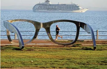  ?? /Reuters ?? I sea you: Cape Town’s Sea Point promenade on Wednesday with The World, an exclusive private residentia­l ship, in the background. The World has already visited Antarctica during its 2024 journey to six continents.