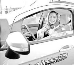  ??  ?? File photo shows a Saudi woman posing for a photo after having a driving lesson in Jeddah. — AFP photo