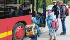  ?? Foto: Sebastian Mayr ?? Hauptkommi­ssar Robert Schlottere­r und Schulbusbe­gleiterin Gunhild Höner helfen Schulkinde­rn beim Einsteigen in den Bus.