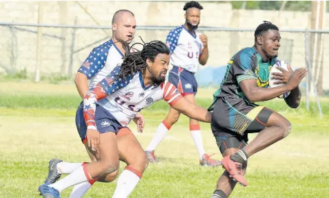  ?? FILE ?? Roland Grey (right) of the Jamaica Reggae Warriors is tackled by Sean Hunt from the USA Hawks during a Rugby League friendly match held at the UWI Bowl in June 2019.