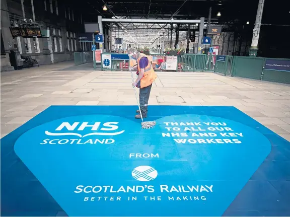  ?? Picture: PA. ?? Members of the cleaning team in Waverley Station, Edinburgh, as Scotland moves into the second phase of easing lockdown.