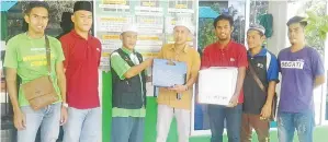  ??  ?? MOHD Sufri (tengah) bersama rombongan menyerahka­n sumbangan kepada AJK masjid dan surau di Daerah Telupid.