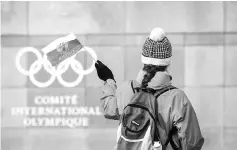  ??  ?? A supporter waves a Russian flag in front of the Internatio­nal Olympic Committee (IOC) headquarte­rs in Pully near Lausanne. — AFP photo