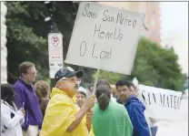  ??  ?? Paul Meza, a parishione­r at San Mateo Catholic Church, holds a sign during a protest outside St. Patrick’s Cathedral in downtown Fort Worth in September 2017.