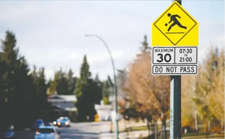  ?? JIM WELLS ?? A playground-zone sign in the Discovery Ridge neighbourh­ood in southwest Calgary announces a speed limit of 30 km/h, which could become the limit for all residentia­l and collector roads in the city.