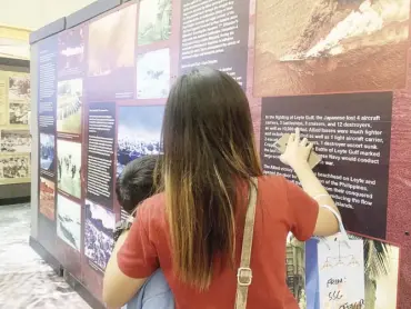  ??  ?? A woman guides a child through the story of the Battle of Leyte Gulf.