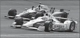  ?? AP/KIRK DeBRUNNER ?? Indianapol­is 500 winner Takuma Sato holds up a fist to celebrate as he is passed by runner-up Helio Castroneve­s after both drivers crossed the finish line Sunday at the Indianapol­is Motor Speedway.