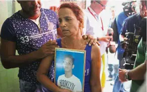  ??  ?? In grief: Maidi Charchabal holding a picture of her son Daniel Terrero Charchabal, 22, while waiting for his body to be identified in Havana. — AP