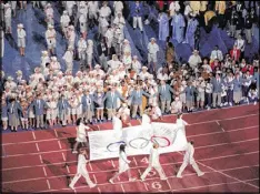  ??  ?? By the time the flag bearers paraded into the stadium, all 197 nations then affiliated with the IOC were represente­d — with 14 competing in the Olympics for the first time.