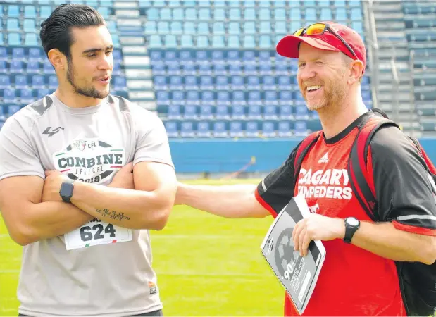  ?? — DAN BARNES ?? Wide receiver Humberto Noriega chats with Calgary Stampeders head coach Dave Dickenson.