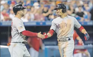  ?? CP PHOTO ?? Boston Red Sox Mookie Betts, left, is congratula­ted by Deven Marrero as he crosses home plate after hitting a two-run home run off Toronto Blue Jays starting pitcher Joe Biagini during sixth inning Major League Baseball action in Toronto on Sunday.