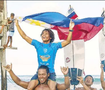  ??  ?? John Mark Tokong proudly displays the Philippine flag after his sensationa­l win in the 25th Siargao Internatio­nal Surfing Cup.