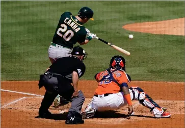  ?? AP PHOTO BY ASHLEY LANDIS ?? Oakland Athletics’ Mark Canha (20) hits a solo home run off in front of Houston Astros catcher Martin Maldonado and umpire Jerry Meals (41) during the second inning of Game 3 of a baseball American League Division Series in Los Angeles, Wednesday, Oct. 7.