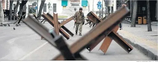  ?? BORJA SÁNCHEZ TRILLO / EFE ?? Un militar patrulla entre una barricada antitanque­s en la ciudad ucraniana de Odesa.