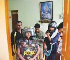  ?? AFP ?? Journalist Kavitha Jakkal (left) and activist Rehana Fatima in protective gear in a building outside the Ayyappa temple complex, as they were denied entry to the temple grounds.