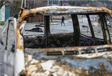  ?? ?? ESTREMECE. Un hombre camina entre los cuerpos de civiles y escombros en una calle situada en el noroeste de Kiev, capital de Ucrania.