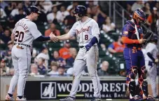  ?? MICHAEL WYKE — THE ASSOCIATED PRESS ?? Detroit Tigers’ Spencer Torkelson (20) and Matt Vierling (8) celebrate behind Houston Astros catcher Martin Maldonado, right, after they scored on a two-run home run by Vierling during the 11th inning of Monday’s game in Houston.