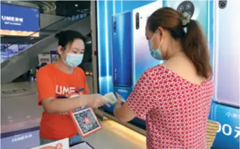  ??  ?? A moviegoer in Beijing gets her temperatur­e taken before she is allowed to go in on July 24