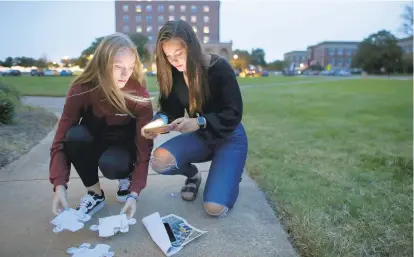  ?? STEPHEN M. KATZ/STAFF ?? Madison Booker, left, and Cassidy Aiken assemble puzzle pieces collected during the Fort Monroe Ghost Walk on Monday.