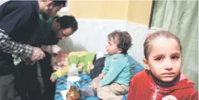 ?? — Gambar AFP ?? MEMILUKAN: Seorang gadis kecil termangu dengan wajah dibasahi air mata duduk di atas katil hospital ketika doktor merawat seorang kanak-kanak kecil bersama seorang bayi yang cedera akibat serangan tentera di Douma, Ghouta Timur kelmarin.